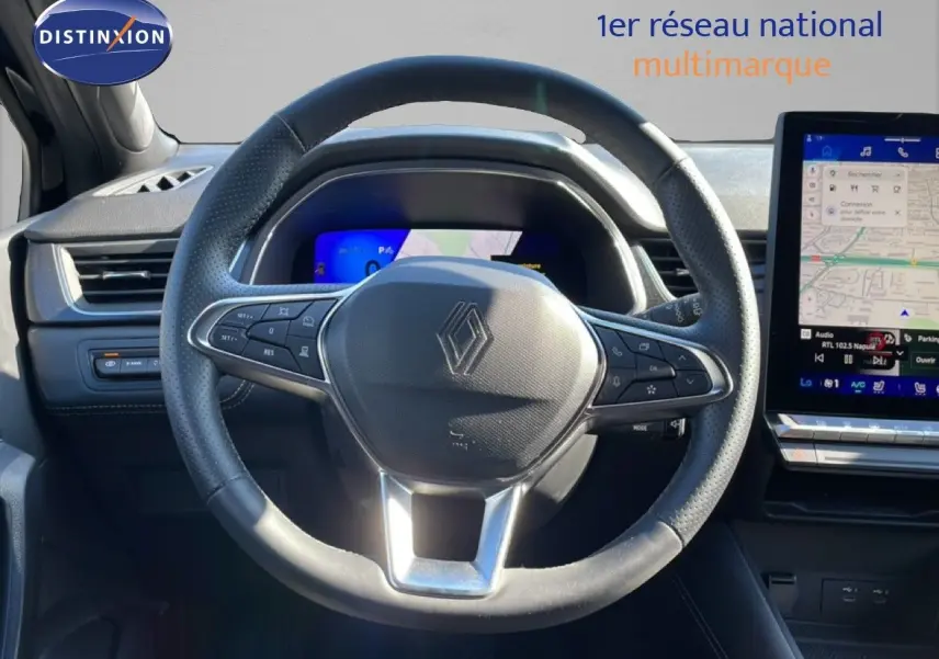 Vue rapprochée du volant noir perforé de la Renault Symbioz 2025 avec tableau de bord digital et écran tactile GPS.