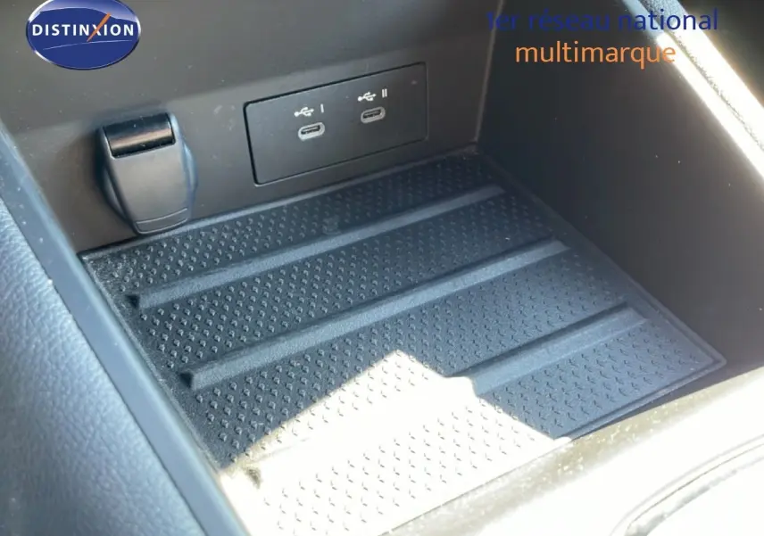 Gros plan sur la console centrale noire du Renault Symbioz 2025, montrant les ports USB-C doubles et un espace de rangement.