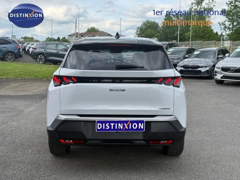 Vue arrière d’un Peugeot 5008 Hybrid blanc Okénite, mettant en valeur ses feux arrière distinctifs et son design moderne.
