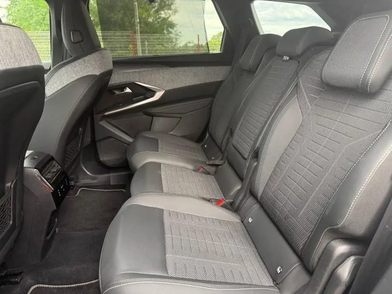 Vue intérieure côté droit des sièges arrière en tissu et cuir du Peugeot 5008 Hybrid 145ch GT 2025, ambiance sobre et moderne.