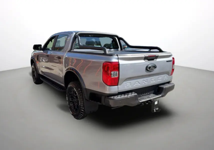 Ford Ranger gris iconic en 3/4 arrière droit, avec arceaux noirs et attelage visible sur la benne.
