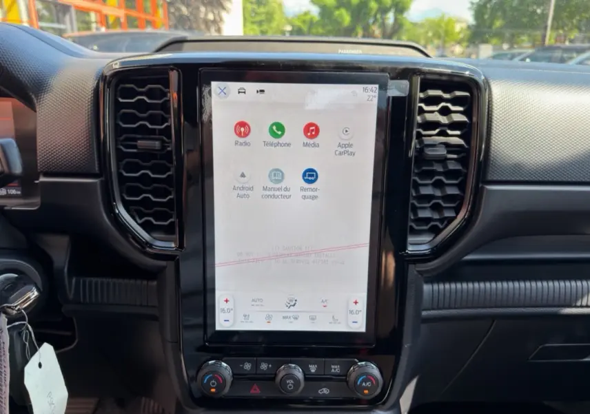 Vue intérieure du tableau de bord du Ford Ranger 2026 avec écran tactile central vertical et commandes climatisation.