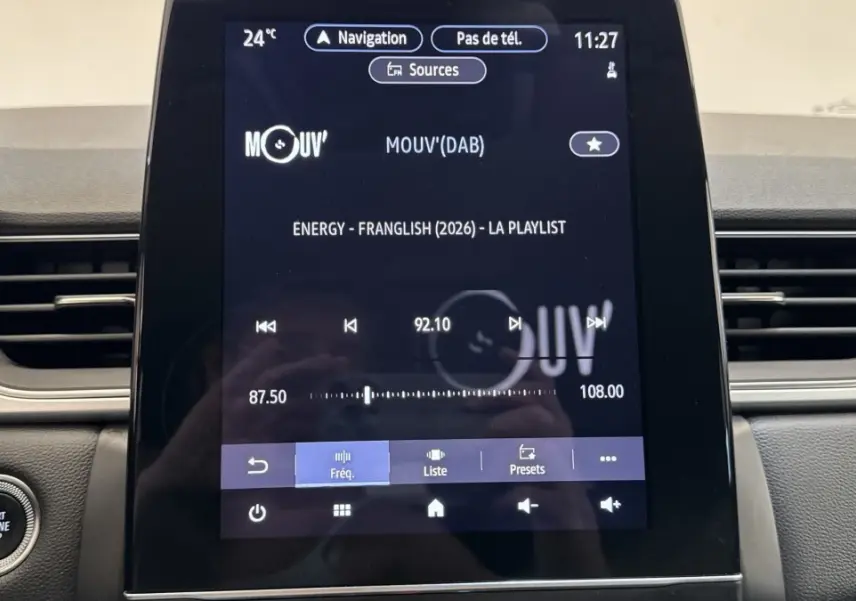 Vue rapprochée de l’écran tactile central du Renault Captur rouge 2024 affichant la radio et les commandes multimédia.