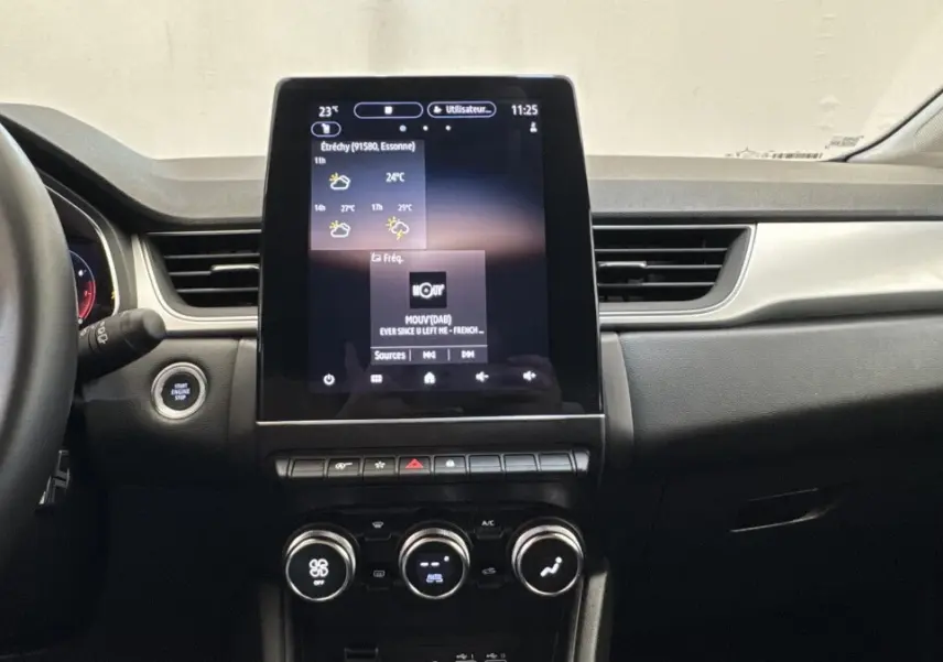 Vue intérieure du tableau de bord du Renault Captur 2024 avec écran tactile central vertical et commandes climatisation rondes.