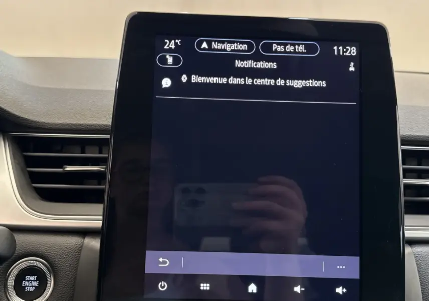 Écran tactile central allumé dans l'habitacle du Renault Captur rouge, affichant le menu de navigation.