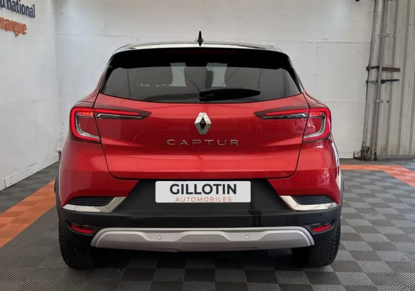Vue arrière d'un Renault Captur rouge 2024 avec feux LED et logo centré sur un sol à damiers noir et orange.