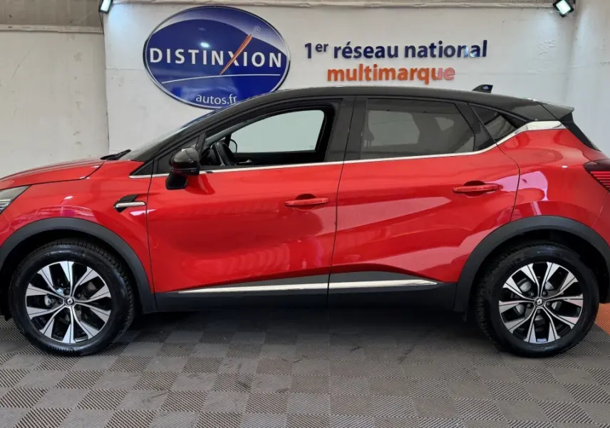 Profil droit du Renault Captur Techno TCe 90 rouge 2024 avec toit noir et jantes alliage bicolores.