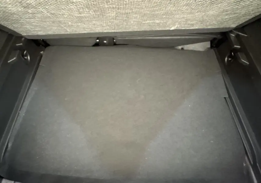Coffre vide du Renault Captur 2024 vu de dessus, avec plancher plat et revêtement gris foncé.