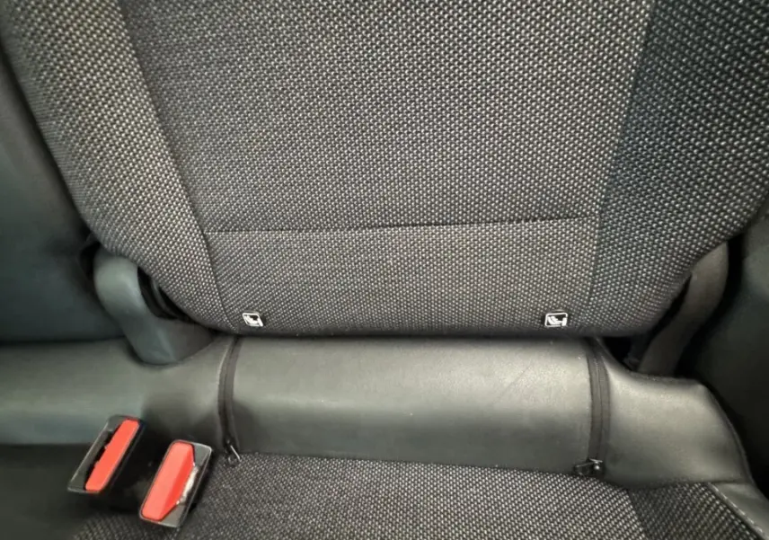 Détail de la banquette arrière noire du Renault Captur 2024, montrant les attaches Isofix et les boucles de ceinture rouges.