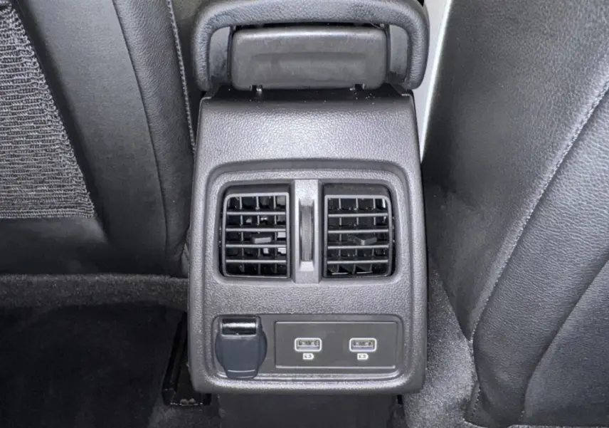 Vue rapprochée de la console arrière noire du Renault Captur 2024 avec bouches d’aération et ports USB.