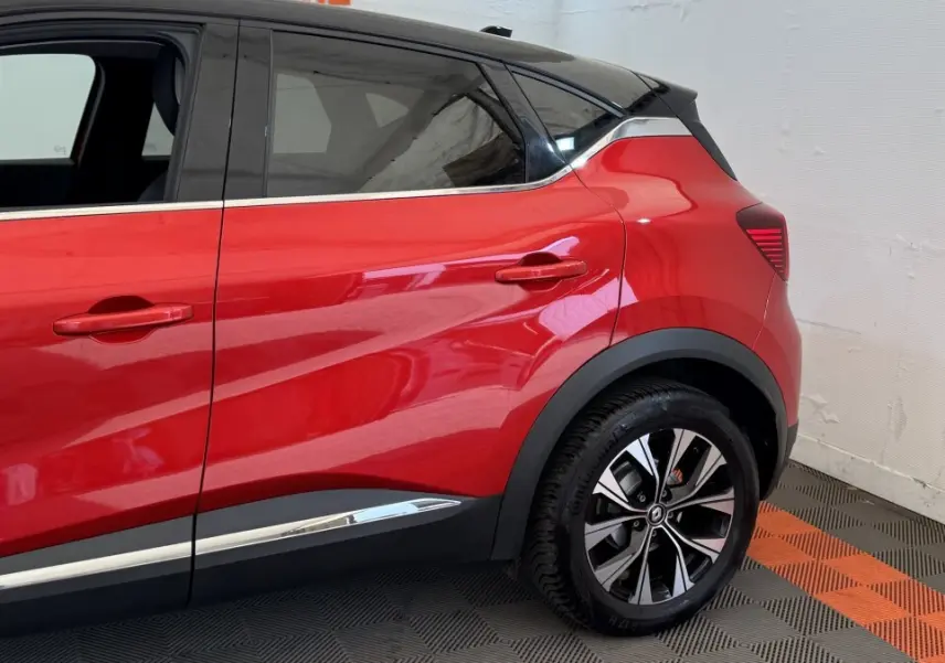 Vue latérale droite du Renault Captur rouge 2024, soulignant la ligne de caisse chromée et les jantes alliage noires.