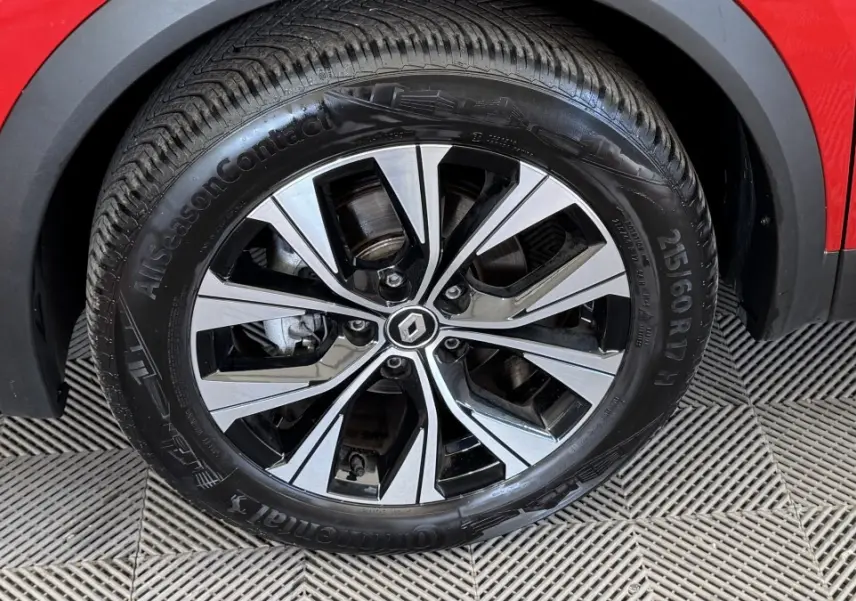 Gros plan sur la roue avant gauche du Renault Captur rouge 2024 avec jante alliage bicolore et pneu Continental.