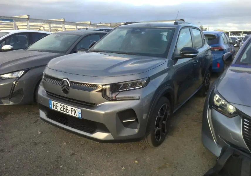 Citroën C3 2025 gris foncé vue 3/4 avant, avec barres de toit noir brillant et jantes 17 pouces Azurite.