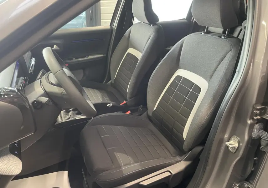 Vue intérieure côté conducteur de la Citroën C3 2025 gris foncé, sièges tissu noir avec inserts gris clair.