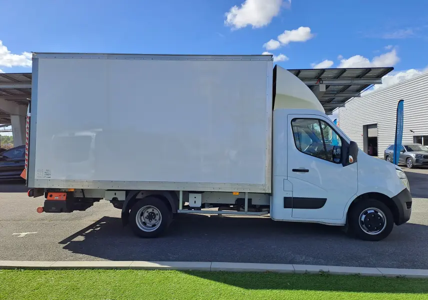 Vue de profil côté droit d’un utilitaire blanc Nissan Interstar Chassis Cabine L3H1 2024 avec caisse fermée sur parking.