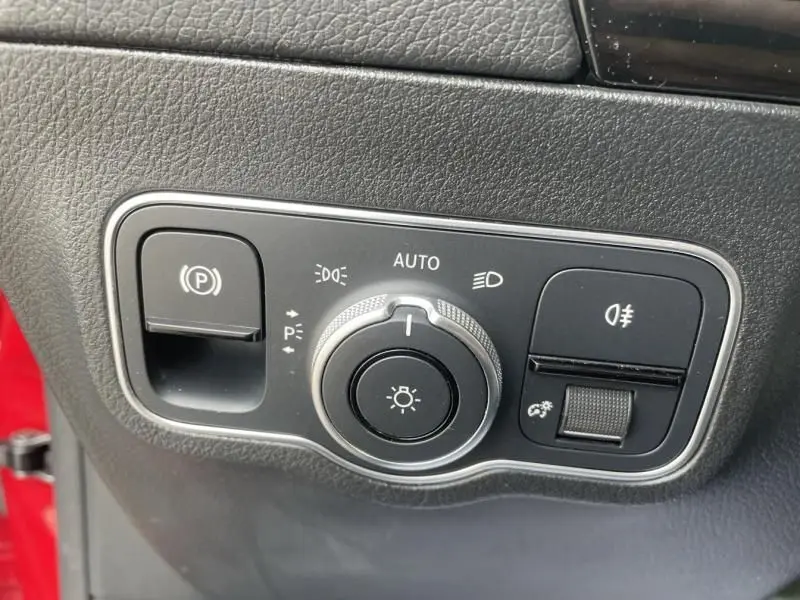 Gros plan sur le panneau de commandes des phares du Mercedes GLA 200 D AMG-LINE rouge métal de 2022.