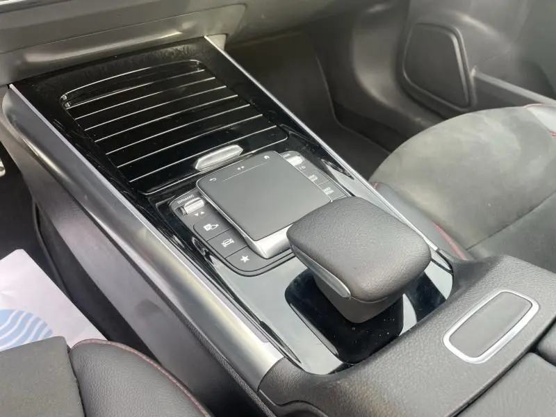 Gros plan sur la console centrale noire brillante du Mercedes GLA 200 D AMG-LINE 2022, avec pavé tactile et levier de vitesse.