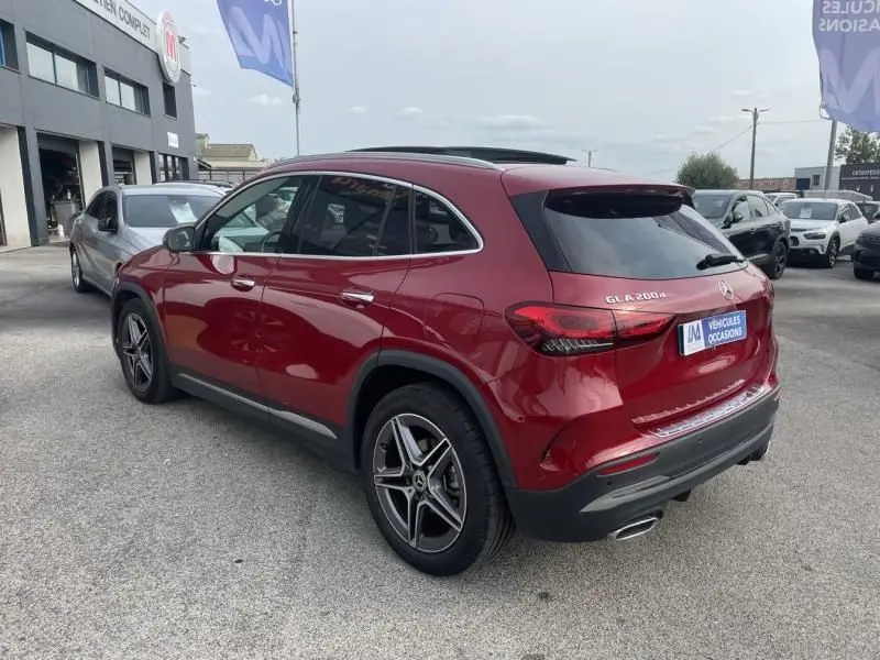 Vue 3/4 arrière droite d'un Mercedes GLA 200 D AMG-Line rouge métal 2022 avec jantes alliage et vitres teintées.