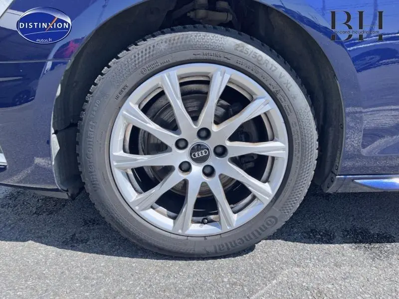 Gros plan sur la roue avant gauche avec jante alu argentée de l'Audi A4 Avant Bleu Navarre métallisé.