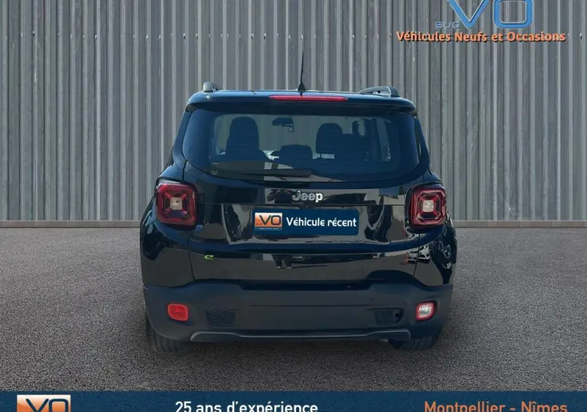 Vue arrière d'un Jeep Renegade noir 2024 avec barres de toit et jantes alliage 18 pouces sur sol goudronné.