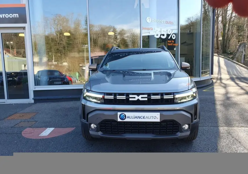 Vue frontale du Dacia Duster 1.6 Hybrid gris schiste, avec signature lumineuse LED et calandre marquée EXC.