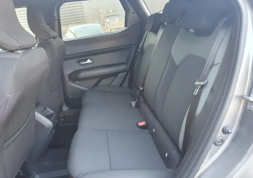 Vue intérieure côté droit sur la banquette arrière noire du Dacia Duster gris schiste 2026, finition hybride.