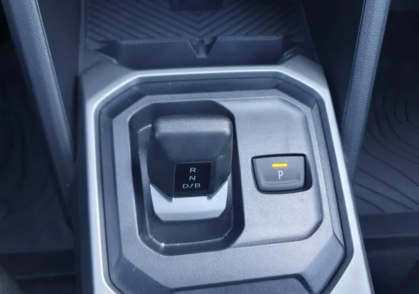 Gros plan sur la commande de boîte automatique noire et grise du Dacia Duster gris schiste, avec bouton de parking éclairé.