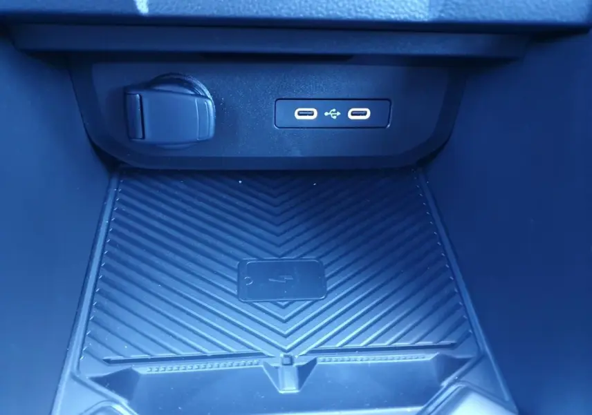 Vue rapprochée de la console centrale du Dacia Duster 2026, montrant les ports USB et un espace de recharge sans fil.