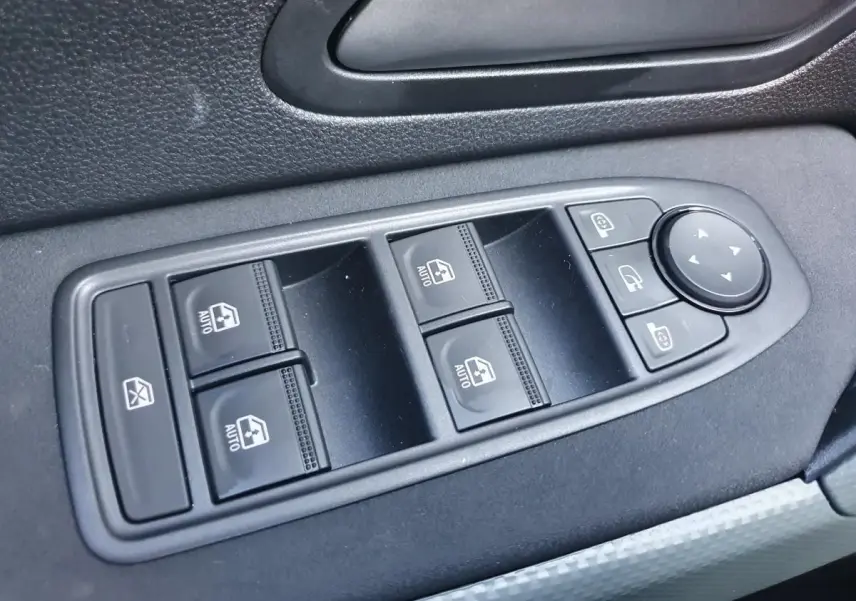 Panneau de commandes des vitres électriques et rétroviseurs côté gauche intérieur du Dacia Duster gris schiste.