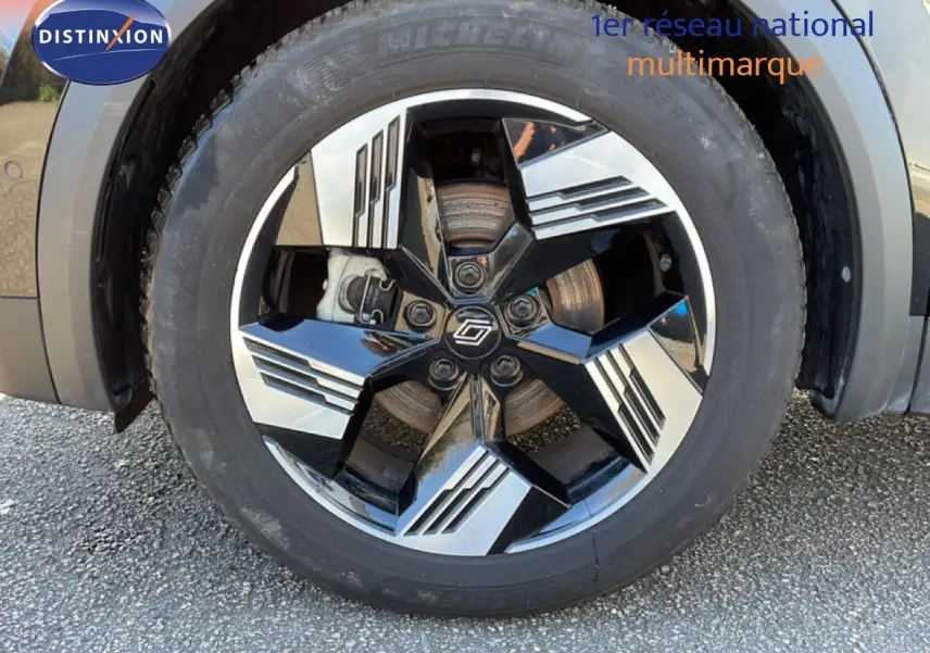 Gros plan sur la roue avant gauche du Renault SYMBIOZ noir étoile métal avec jante noire et argentée au design géométrique.