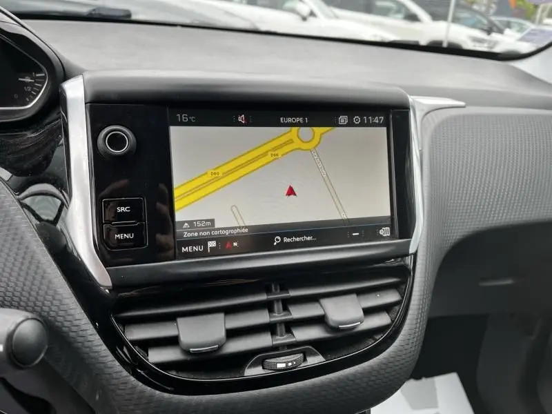 Vue rapprochée de l’écran tactile central du tableau de bord du Peugeot 2008 blanc de 2019 avec navigation affichée.