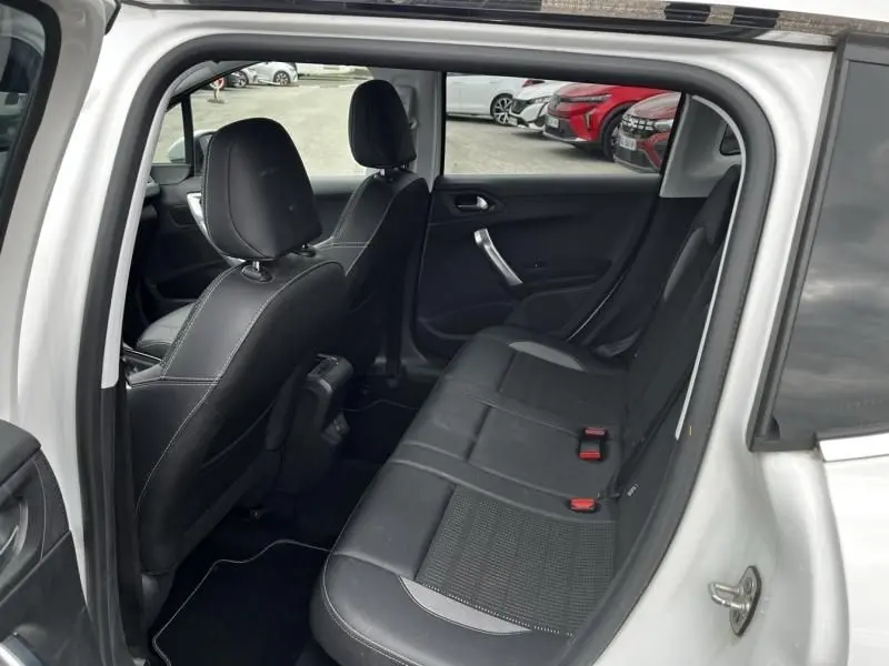 Vue intérieure côté droit arrière du Peugeot 2008 blanc 2019, montrant les sièges noirs en tissu et cuir avec appuie-têtes.