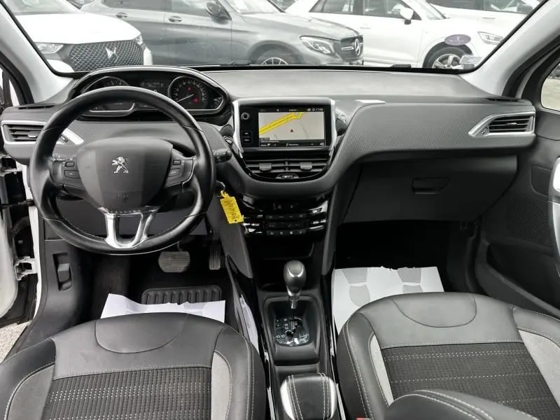 Vue intérieure avant du Peugeot 2008 blanc 2019, montrant le tableau de bord avec écran tactile et volant multifonction.