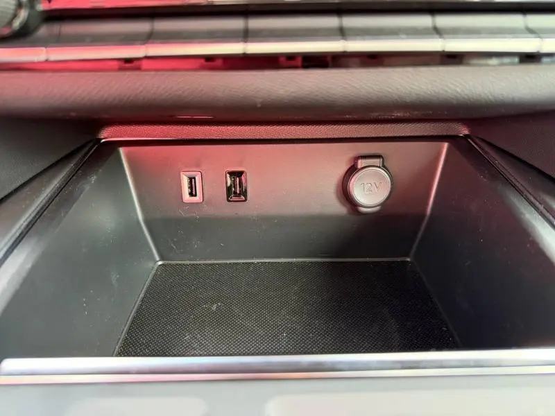 Vue rapprochée de la console centrale noire du Citroën C5 Aircross 2025, montrant deux ports USB et une prise 12V.