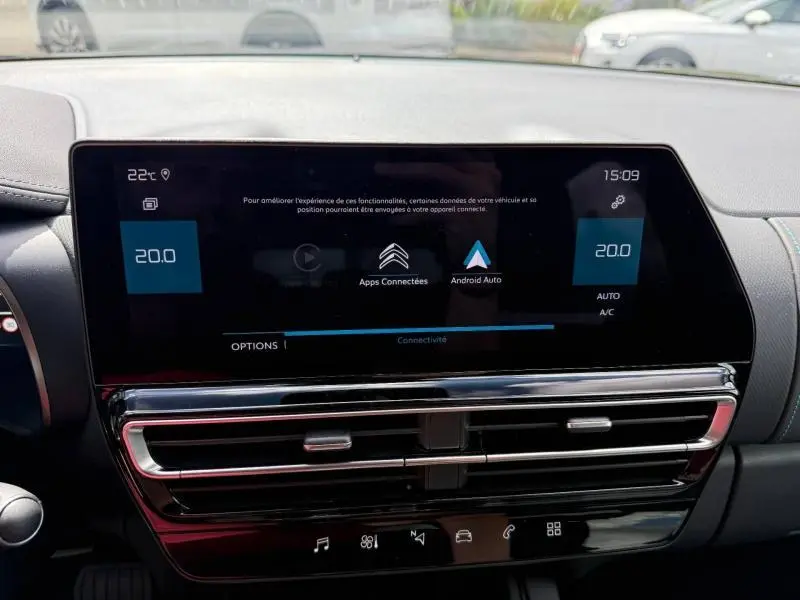 Écran tactile central du tableau de bord du Citroën C5 Aircross 2025, affichant la climatisation à 20°C et les options connectées.