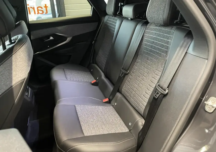 Vue intérieure côté droit sur la banquette arrière gris foncé et tissu chiné du Peugeot 3008 hybride 2025.
