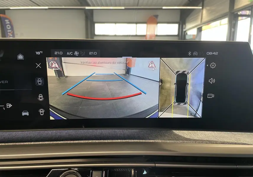 Vue de l'écran intérieur du Peugeot 3008 affichant la caméra de recul et la vue 360° du véhicule en stationnement.