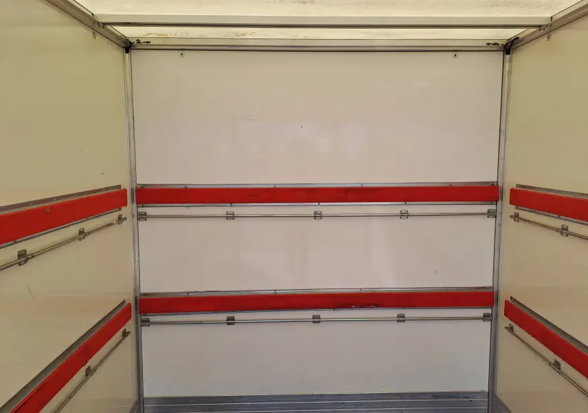 Vue intérieure de la caisse blanche du Nissan Interstar Chassis Cabine 2024, avec rails et protections rouges sur les parois.