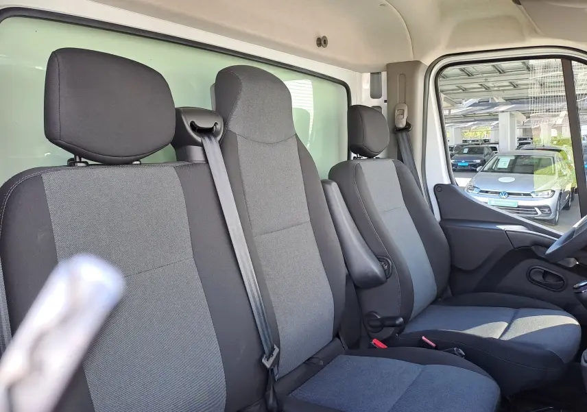 Vue intérieure côté droit du Nissan Interstar Châssis Cabine 2024, montrant les sièges gris et noir avec ceinture de sécurité.