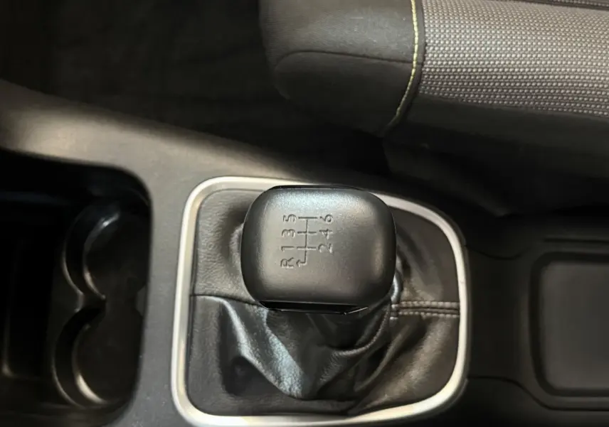 Le levier de vitesses manuel noir de la Citroën C3 2019, vu de dessus avec sellerie grise à coutures jaunes.