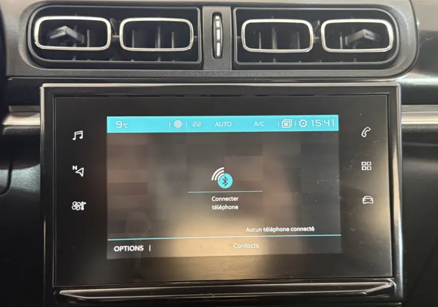 Écran tactile central allumé avec interface Bluetooth dans l'habitacle noir d'une Citroën C3 gris clair.