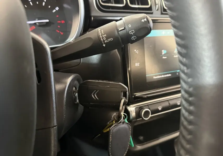 Gros plan sur le neiman avec clé Citroën insérée dans le tableau de bord noir de la C3 Shine Business 2019.