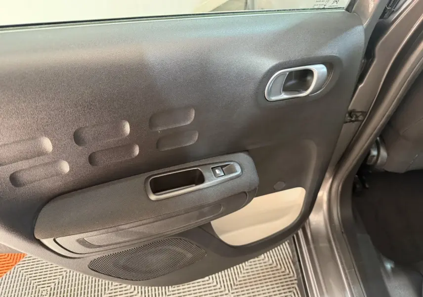 Vue rapprochée de la porte arrière droite gris clair de la Citroën C3 2019 avec poignée et commande de vitre électrique.
