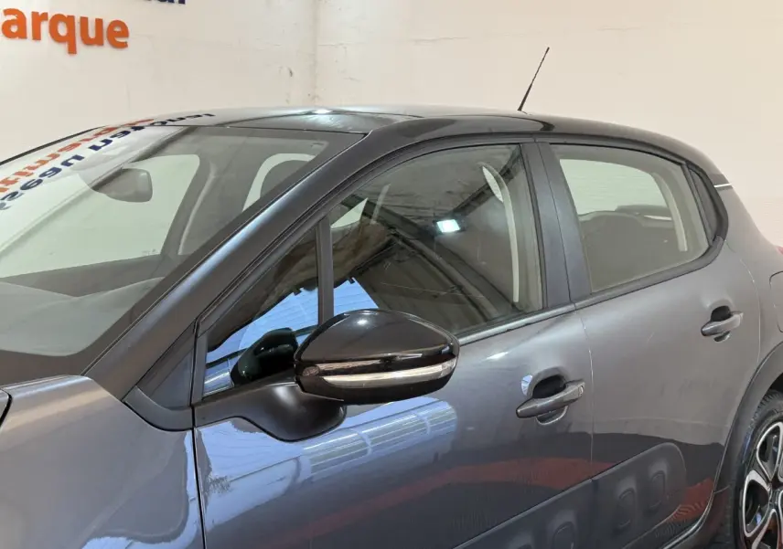 Profil côté gauche d'une Citroën C3 gris clair 2019 avec protections latérales noires et rétroviseur ton caisse.