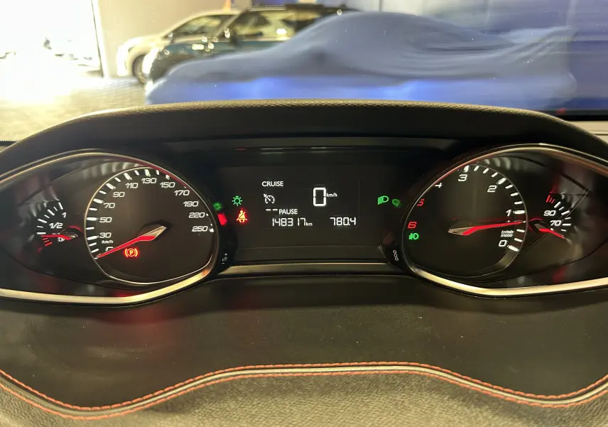 Vue rapprochée du tableau de bord de la Peugeot 308 noir, affichant le compteur digital et les voyants allumés.