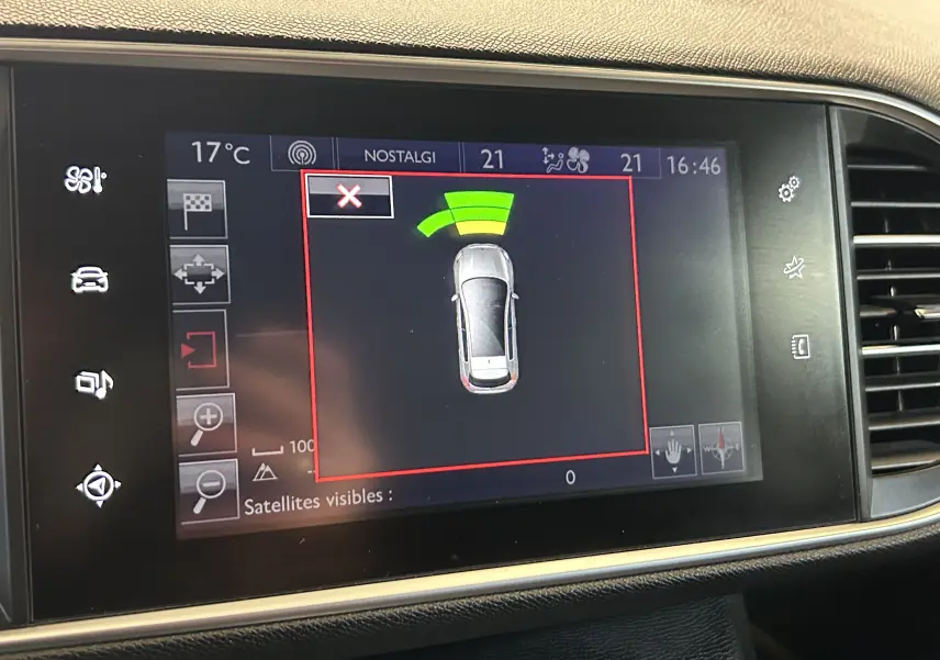 Écran tactile intérieur montrant l'alerte radar de recul de la Peugeot 308 noire, vue de dessus du véhicule.