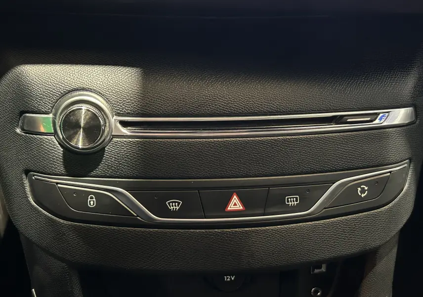 Gros plan sur la console centrale noire de la Peugeot 308 GT Line 2017, avec boutons de verrouillage, hazard et recyclage d'air.