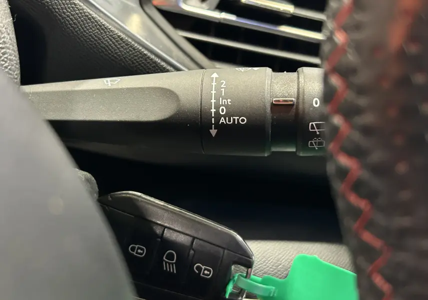 Gros plan sur la manette d’essuie-glace et la clé noire avec bouton, intérieur noir de la Peugeot 308 GT Line 2017.