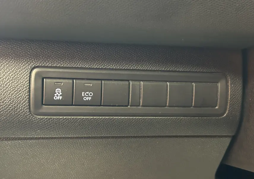 Gros plan sur les boutons de commande du tableau de bord noir de la Peugeot 308 GT Line 2017, avec fonctions ABS et ECO off.