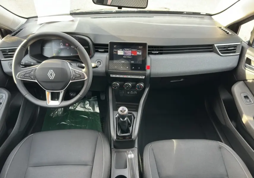 Vue intérieure avant de la Renault Clio DCI 100 Evolution avec tableau de bord moderne, volant cuir multifonctions et boîte manuelle.